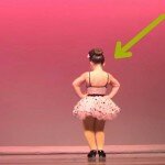 3 meninas estão no palco, mas espere até a do meio se virar. Aos 0:10, o público vai ao delírio!